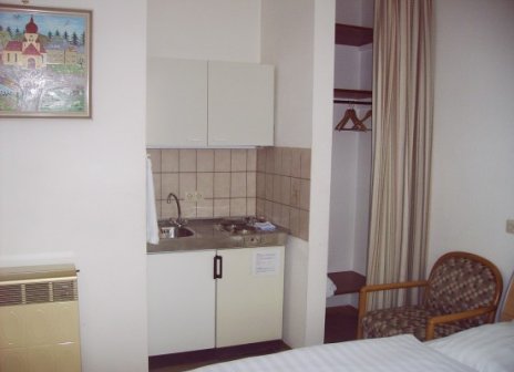 Zimmer mit Kochzeile und Einzelbett